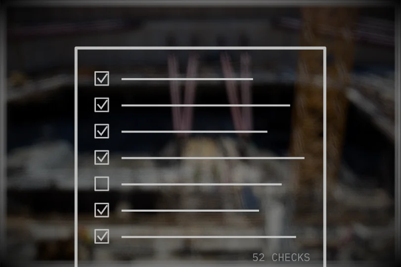 A checklist with most boxes ticked, drawn over an industrial site